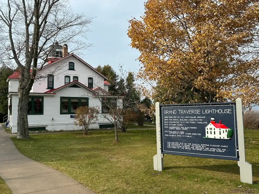 &lsquo;Grand Traverse Lighthouse with sign displaying significant dates in its history.&rsquo;